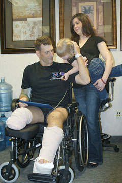 Todd E. Hammond shows his Purple Heart medal to his two-year-old daughter (credit: U.S Navy)