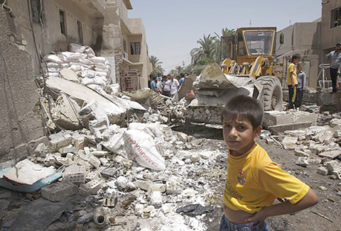 A boy surveys the aftermath of a bombing in Baghdad in June