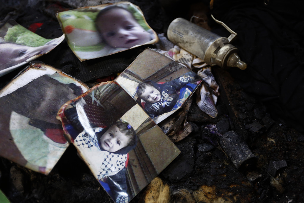 Burnt photographs of 18-month-old Ali Dawabsha are seen in Ali's fire damaged room in the West Bank village of Douma near Nablus City, 31 July 2015. The Palestinian infant was killed and several people injured when their home was set alight in the northern West Bank early 31 July 2015, an official said. A group of masked people believed to be Israeli settlers threw flammable bombs into two houses on the outskirts of the village of Doma, south of Nablus, said Ghassan Daghlas, a Palestinian Authority official.  EPA/ALAA BADARNEH
